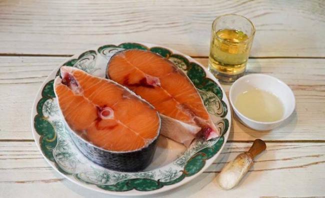 Ингредиенты для приготовления стейков из кеты Кета, лимонный сок и масло