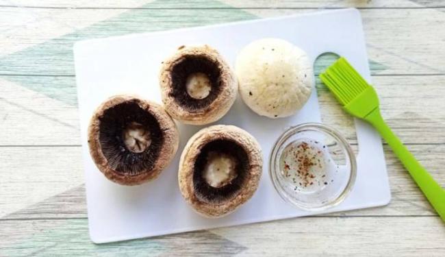 Смазывание шампиньонов маслом со специями Шампиньоны и масло