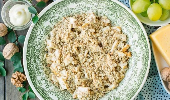 Куриный слой, посыпанный измельчёнными грецкими орехами  Копчёная курица с грецкими орехами