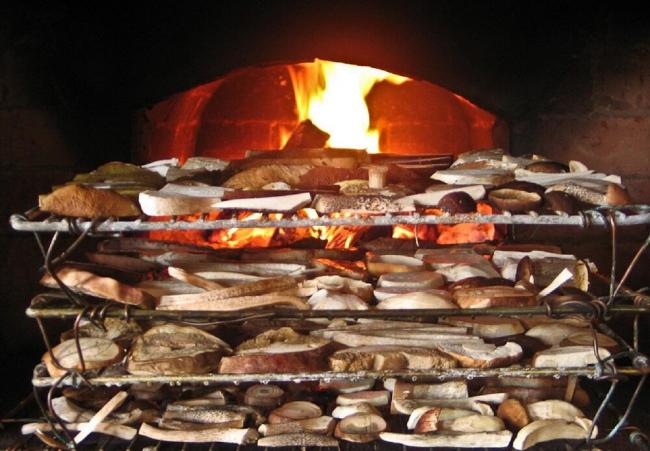 Высушенные маслята возле русской печи Нарезанные грибы рядом с печью