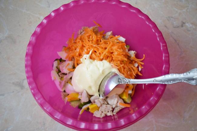 Перемешивание ингредиентов салата с курицей, огурцом и морковью Перемешивание салата с огурцом и морковью