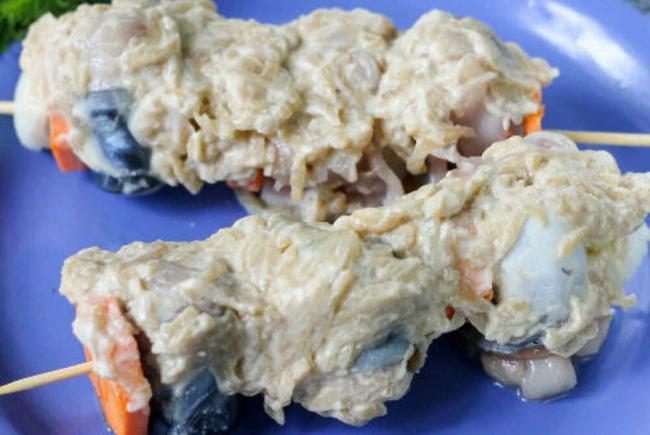 Кусочки рыбы в маринаде из яблок и лука На голубой тарелке кусочки рыбы в маринаде из яблок и лука