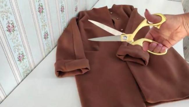 Распарывание старого пальто Старое пальто и ножницы