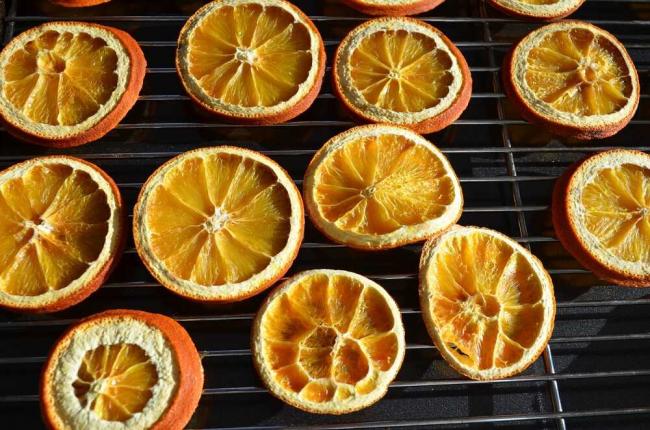 Кружочки апельсинов сушатся в духовке Сушеные апельсины на решетке