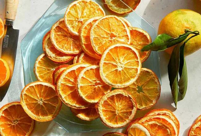 Гора сушеных апельсинов Сушеные апельсины на стеклянной тарелке