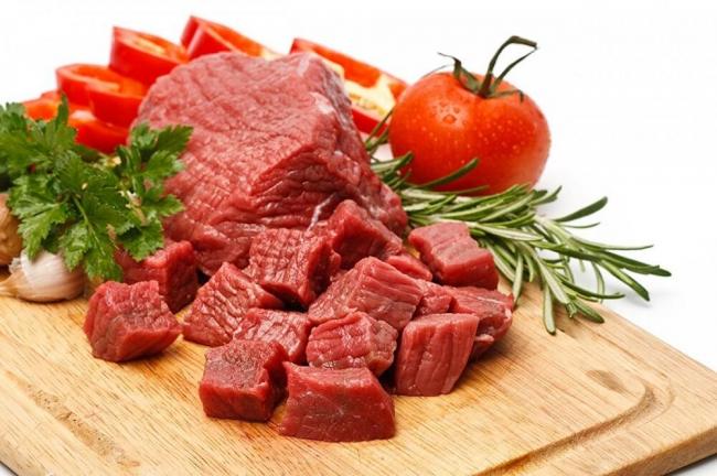 Говядина, нарезанная кусочками Свежее мясо говядины с помидорами и зеленью