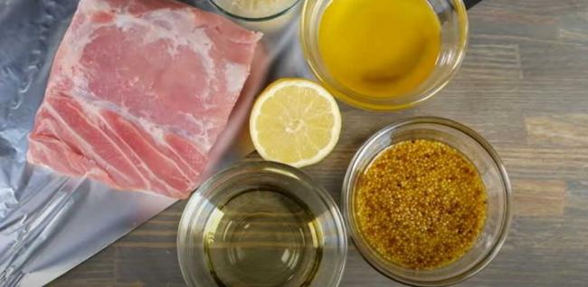 Свинина в окружении горчицы, меда, масла, лимона Нас толе расположен кусок свинины, горчица, лимон, мед, масло