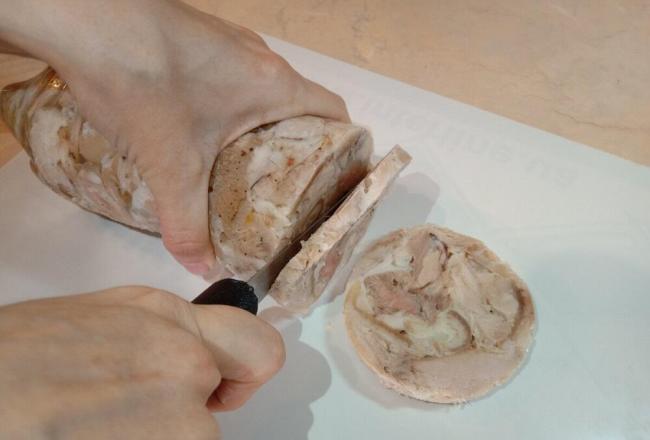 Нарезка куриной ветчины из бутылки Женщина режет домашнюю ветчину